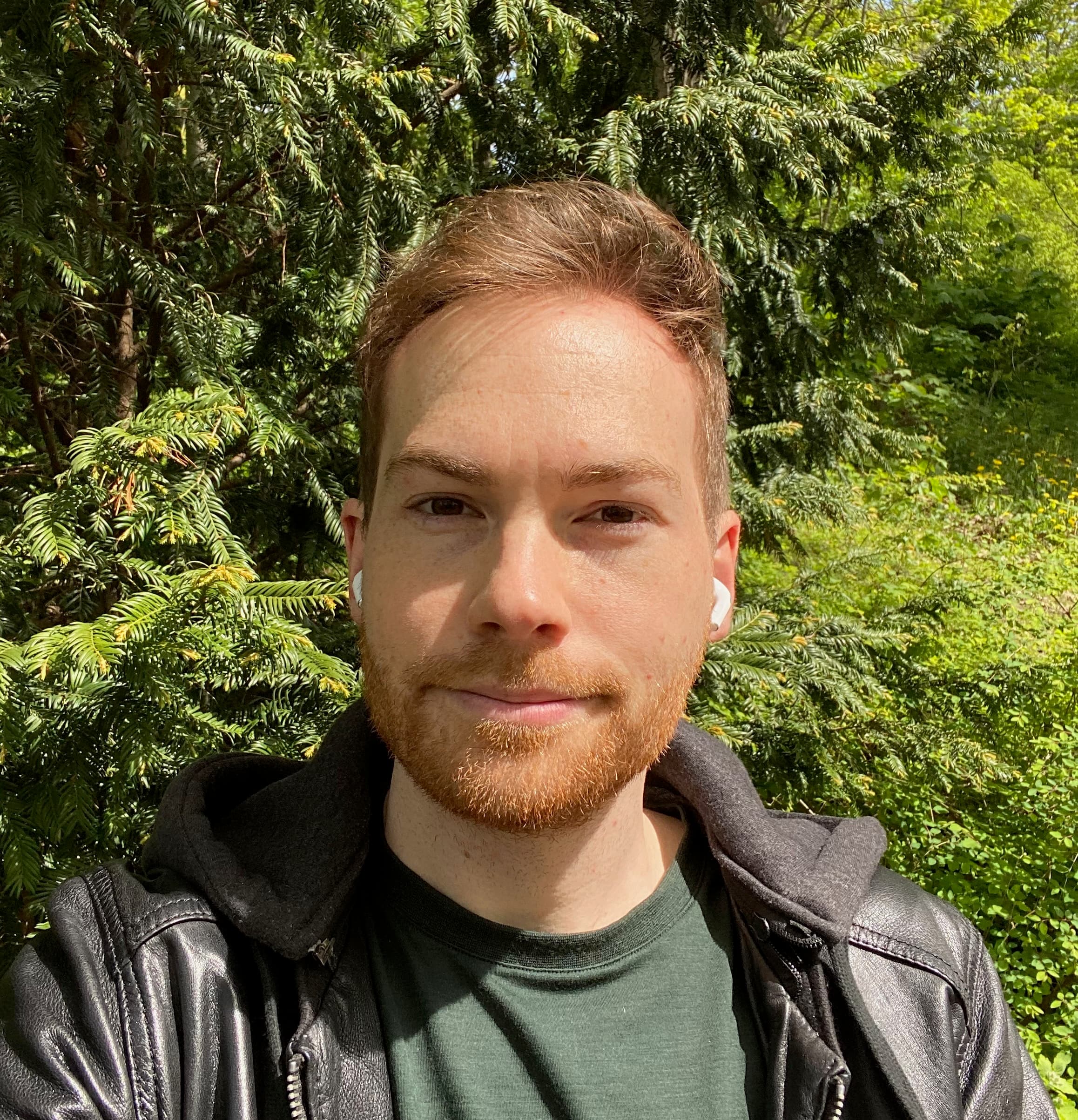 Daniel, Mitgründer von FoodQuest, vor grünen Bäumen