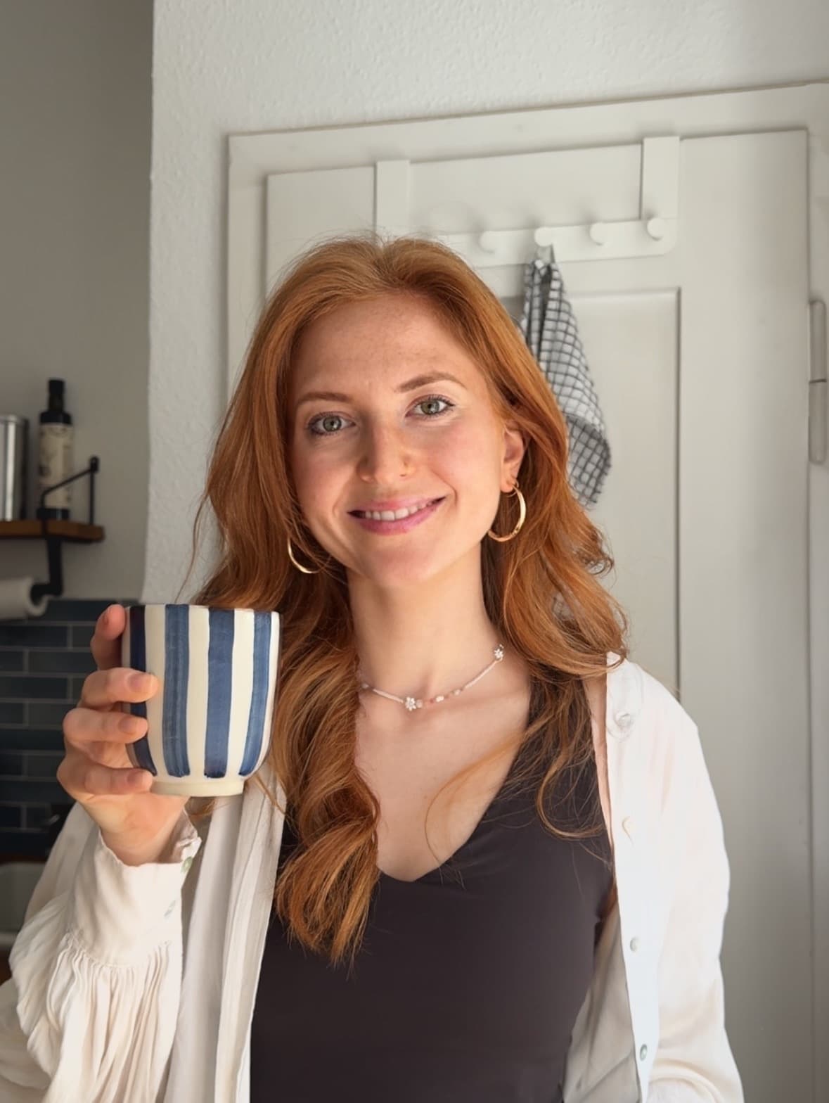 Teresa, Mitgründerin von FoodQuest, mit einer gestreiften Kaffeetasse
